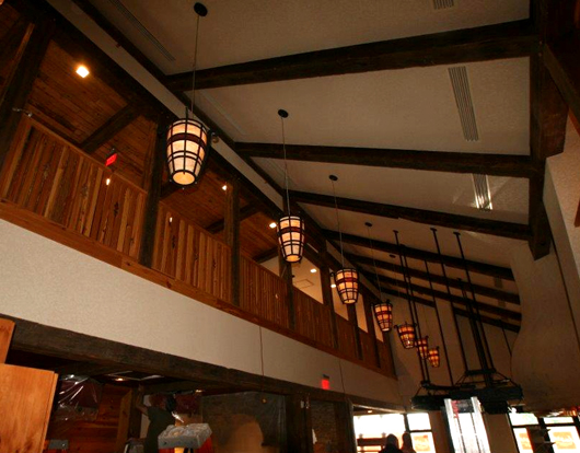 The industrial salvaged timbers with original patina adorn the ceiling and frame the loft area of the restaurant. 